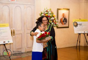 St. Hugh's High School student Brianna Miller presents the Poet Laureate with a bouquet of roses